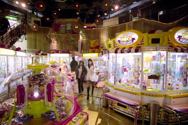 Deux jeunes femmes traversent une salle de jeux dans Shibuya.