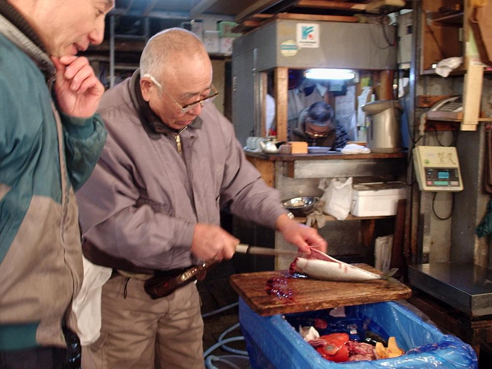 Un homme apprête un poisson