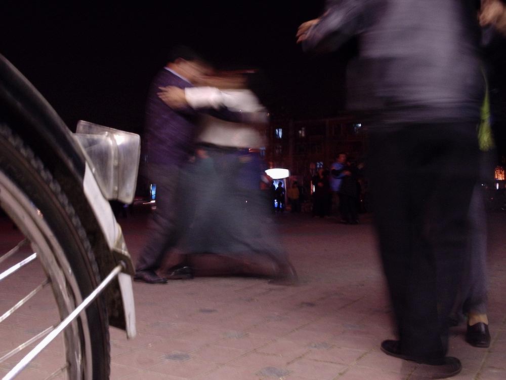 Des gens valsent sur le trottoir.